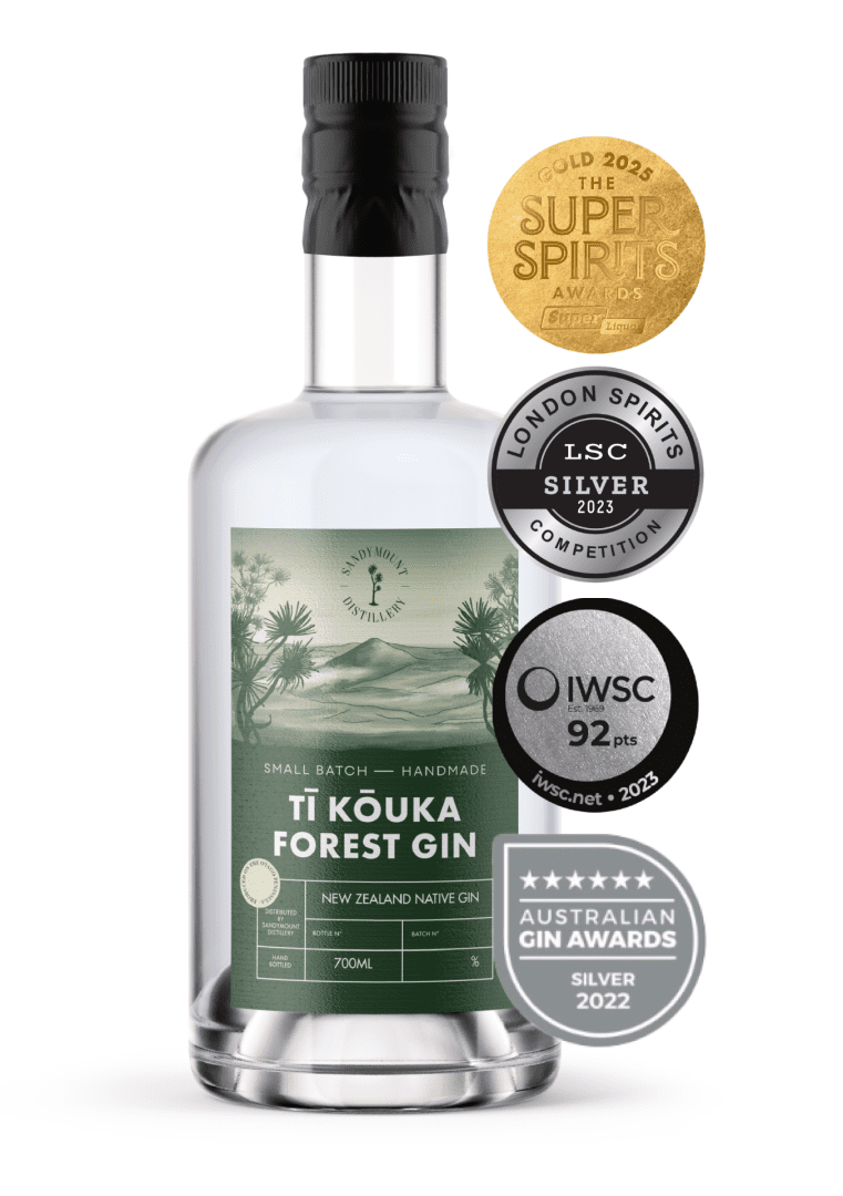 A clear glass bottle with clear liquid in it and a label on the front. The green label has illustrations of bush and a hill landscape, titled Tī Kōuka Forest Gin